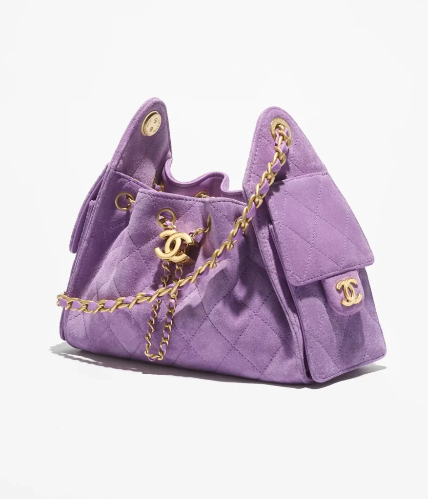 Purple quilted handbag with a gold chain strap and Chanel logo hardware