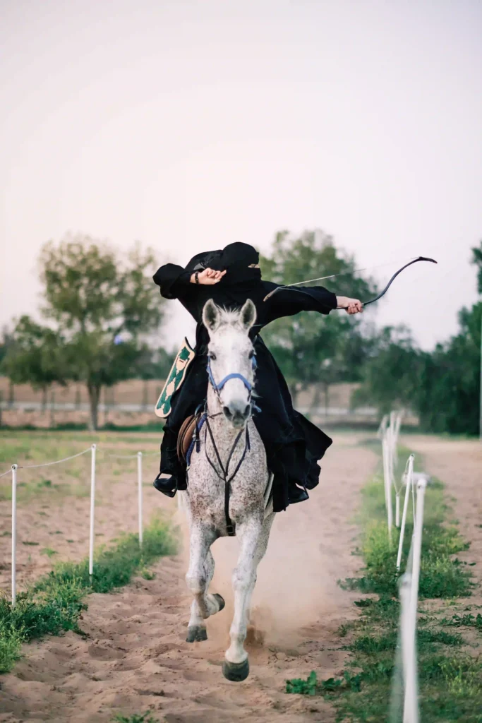 Aamina Shifa riding a horse and shooting an arrow