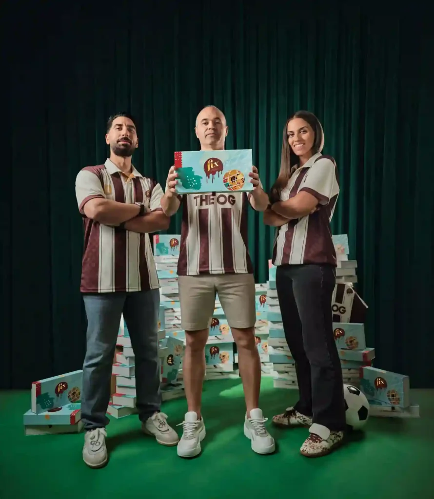 An image of three people wearing the FIX Dessert Chocolatier football jersey