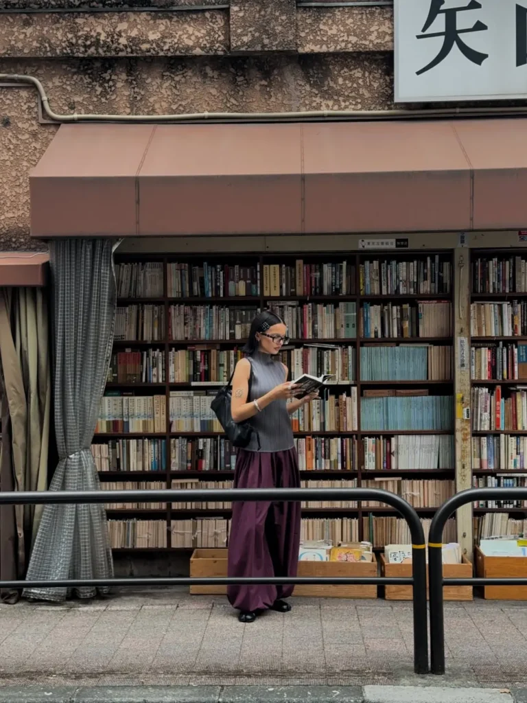 A woman reading a book outside an open book store in Kanda-Jinbōchō that reflect Middle Eastern travel habits