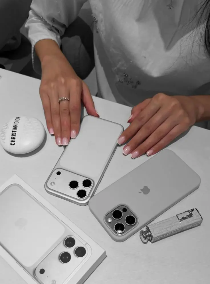 Women with two iPhones as a visual indicator for our iPhone 18 details article.