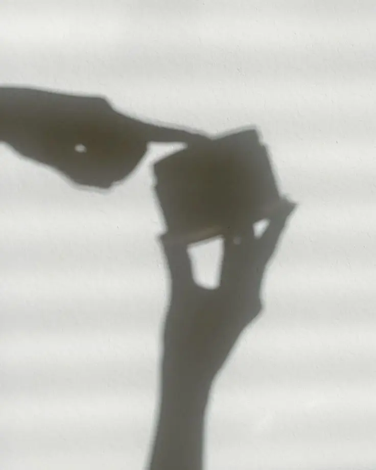 Image of a shadow hand putting their finger in a jar